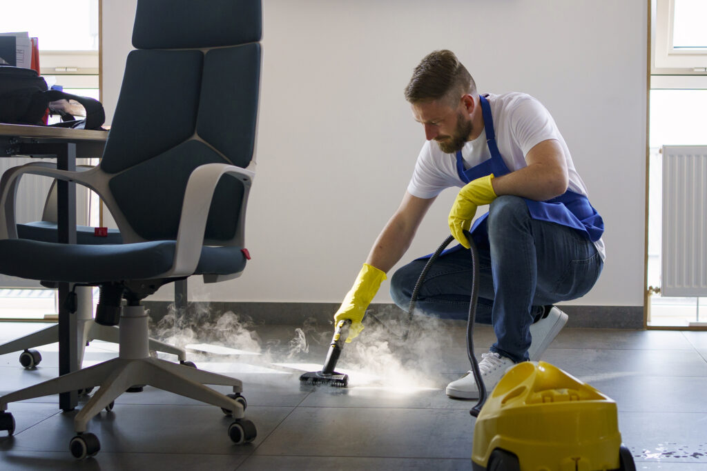 professional cleaning service person using steam cleaner office
